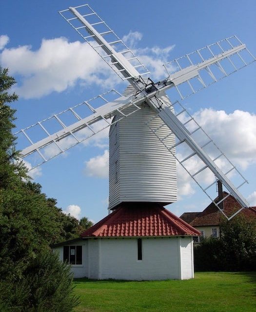 Un mulino a vento nella campagna olandese simboleggia la sostenibilità aziendale e il suo impatto positivo sui rendimenti finanziari e assicurativi.